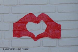 Ein gezeichnetes Herz aus roten Händen auf weißer Wand. Bild von Elsemargriet auf Pixabay